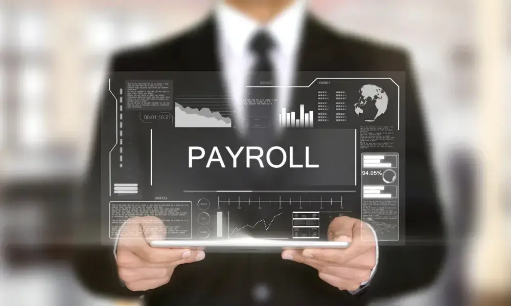 Businessperson holding a transparent digital tablet displaying payroll data and charts in canada