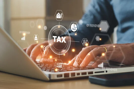 Person on laptop with virtual tax icons and graphics overlay in canada